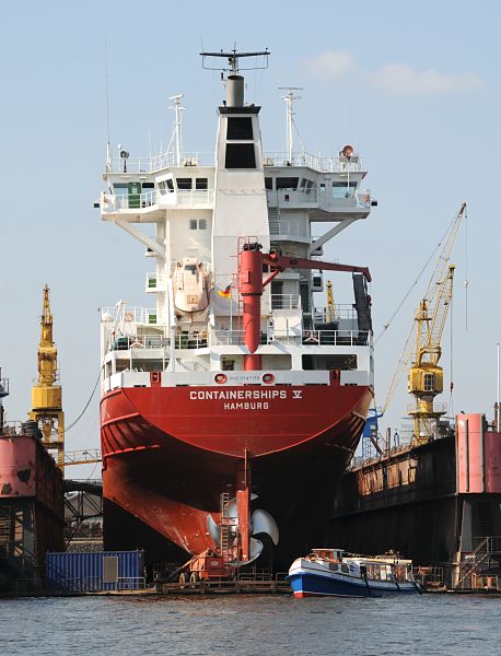 Frachtschiff im Dock / Werft Hamburger Hafen  011_26-5959Das Frachtschiff Containerships V ist im Hamburger Hafen eingedockt und bekommt eine neue Schiffschraube. Links und Rechts vom Trockendock zwei Werftkrane. Eine Barkasse der Hamburger Hafenrundfahrt zeigt den Hamburg Touristen die Arbeit im Hamburger Hafen. www.hamburg- fotograf.com