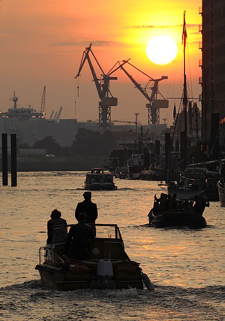 011_70_26040 Barkassen fahren aus dem Sandtorhafen Richtung Elbe -  die Abendsonne steht tief am Himmel des Hamburger Hafens.Sonnenuntergang im Hafen Hamburgs; Hafenkräne Barkassen.