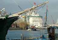 011_72_66826 Hinter dem Vordersteven des Museumsschiff RICKMER RICKMERS liegt das Passagierschiff FREEDOM OF THE SEAS im Trockendock der Hamburger Werft Blohm + Voss. Eine Hafenfhre kreuzt die Elbe vor den St. Pauli Landungsbrcken, um dort anzulegen.