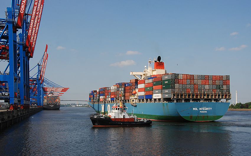 011_15578 ein Schlepper zieht das Schiff an die Kaianlage des Container Terminals Altenwerder- die Containerbrücke ist noch hochgeklappt - ein anderer Containerfrachter wird am Kai des Hamburger Hafens entladen; im Hintergrund die Köhlbrandbrücke und die Elbe. 