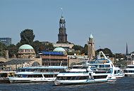 011_26077 Schiffe der Hafenrundfahrt Hamburgs liegen an den St. Pauli Landungsbrcken - die Rundfahrt durch den Hamburger Hafen und die Speicherstadt ist eine beliebte Touristenattraktion. Das Abfertigungsgebude mit den beiden kupfergedeckten Kuppeln und dem Tide- und Uhrenturm wurde von 1907 - 1909 aus Tuffstein errichtet. Die Landungsbrcken haben eine Lnge von ca. 205 m; die Anlage wurde 2003 unter Denkmalschutz gestellt. Hinter dem Gebude der Jugendherberge am Stintfang ragt das Hamburger Wahrzeichen, der Turm der Michaeliskirche empor. Auf der Plattform unter der Kuppel geniessen die Hamburger Touristen den Ausblick ber die Hansestadt, die Elbe und den Hafen. www.hamburg-fotograf.com