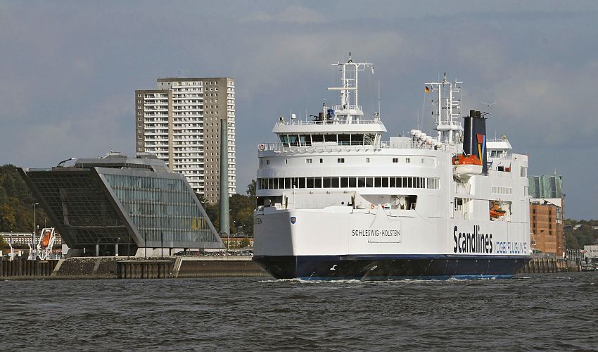 Fotos aus dem Hamburger Hafen und von den Schiffen auf der ELbe / Fhrschiff Schleswig-Holstein   011_26081 Das Fhrschiff SCHLESWIG-HOLSTEIN der Scandlines Vogelfluglinie vor Hamburg Neumhlen; lks. das moderne Brogebude Dockland der Architekten Bothe Richter Teherani. Die Fhre fhrt auf der Elbe Richtung Nord-Ostsee-Kanal zu ihrem Heimathafen Puttgarden. Das Schiff hat eine Lnge von 142m und kann 1040 Passagiere sowie 110 PKW an Bord nehmen. www.hamburg-fotograf.com