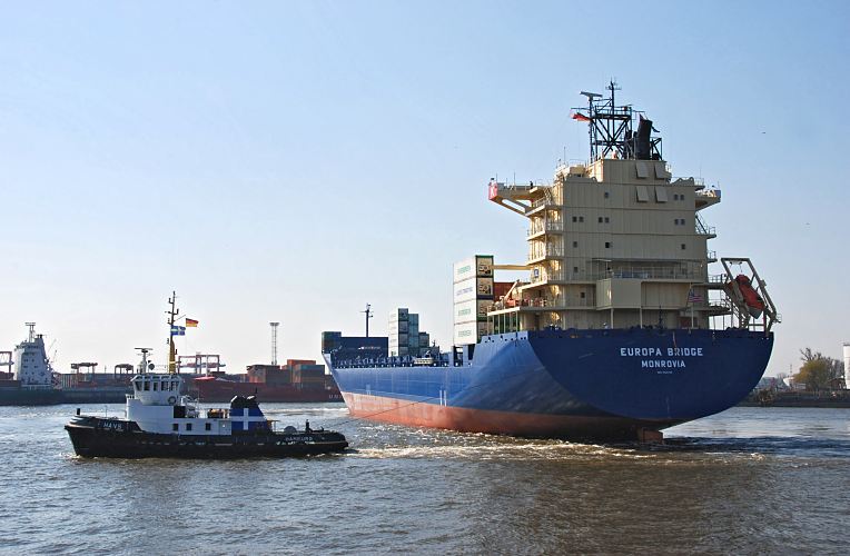 Hamburgbilder - Hafenfotos / Containerschiff und Hafenschlepper im Waltershofer Hafen  011_26085 Der Container Feeder EUROPA BRIDGE hat seinen Heimathafen in Monrovia - der Frachter ist gerade in den Hamburger Hafen eingelaufen und wird von einem Hafenschlepper bei dem Wendemanver im Waltershofer Hafen untersttzt. Im Hintergrund liegen Containerschiffe am Predhlkai vom Container Terminal EUROGATE.  www.hamburg- fotograf.com