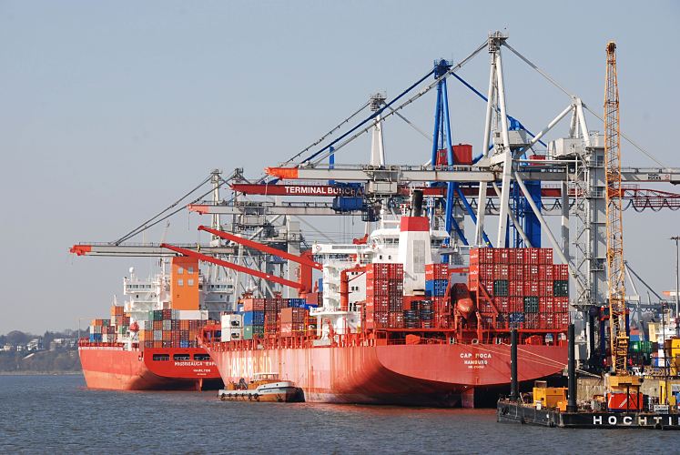 Hamburg-Fotografie; Bilder aus dem Hamburger Hafen - Container-Schiffe am Hafenkai  011_26087 Zwei rote Containerfrachter liegen am Kai des Waltershofer Hafens; die Containerbrcken sind herunter gefahren, die Schiffe werden be- und entladen. Rechts ein Schwimmkran, der an der Befestigung der Kaianlage vom Termianl Burchardkai arbeitet, damit dort ein Liegeplatz mit modernen Krananlagen entstehen kann. www.hamburg- fotograf.com