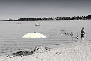 0954 Badestrand an der Schlei in Schleswig - Sandstrand beim Neubaugebiet Auf der Freiheit. Badende Familien im Wasser - Sonnenschirm im Sand; Boote auf der Schlei.