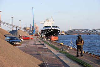 6655 Frachtschiff am Kirchenpauerkai - Angler stehen zwischen dem Schttgut an der Elbe und angeln. Im Hintergrund die Norderelbbrcken.