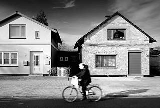 5010 Wohnhuser - Einzelhaus, unterschiedliche Fassadengestaltung / Klinkerfassade, Ziegelfassade + glatt verputzte Hausfassade - Radfahrer in Fahrt, Schwarz-Weiss Darstellung