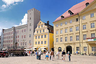 3040 Haidplatz in Regensburg - lks. das Goldene Kreuz, Patrizierburg - Haus mit Zinnen und Turm. Rechts das klassizistische Thon Dittmer Palais - Touristen berqueren den Platz in der Sonne.