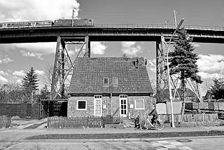 0202 Einfaches Backstein-Wohnhaus mit Spitzdach unter der Eisenbahnhochbrcke von Rendsburg - Schwarz Wei Aufnahme.