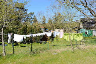 180_6758 Wohnhaus mit einzelnd stehenden Einraum-Ferienhusern - Wsche hngt zum Trocknen auf der Leine; Ostseebad Zingst, Mecklenburg-Vorpommern.